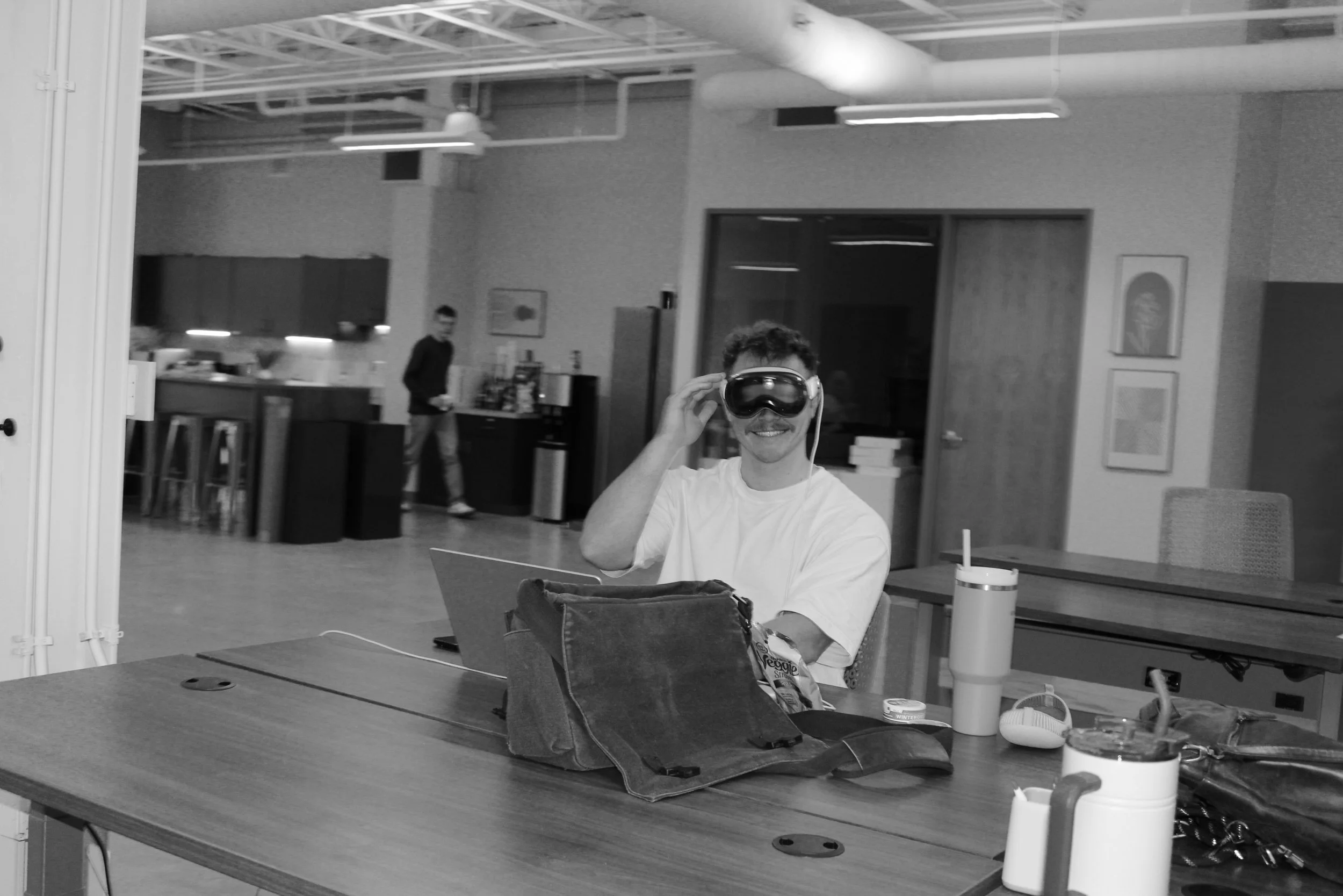 A person experimenting with a headset at a desk in the Foundry space before its rebrand